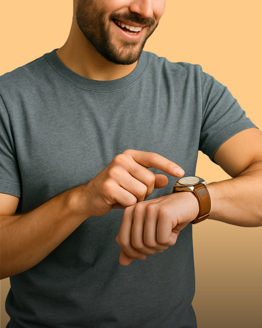 Ein Mann schaut lächelnd auf seine Armbanduhr und tippt darauf.